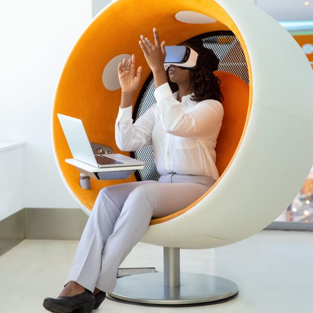 Focused woman testing VR headset. Thoughtful African American tester wearing virtual reality glasses. Technology concept